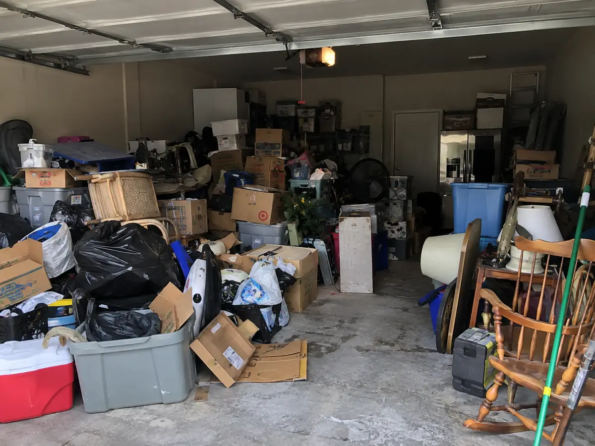 Before: a two-car garage packed with boxes, bins, bags and old furniture